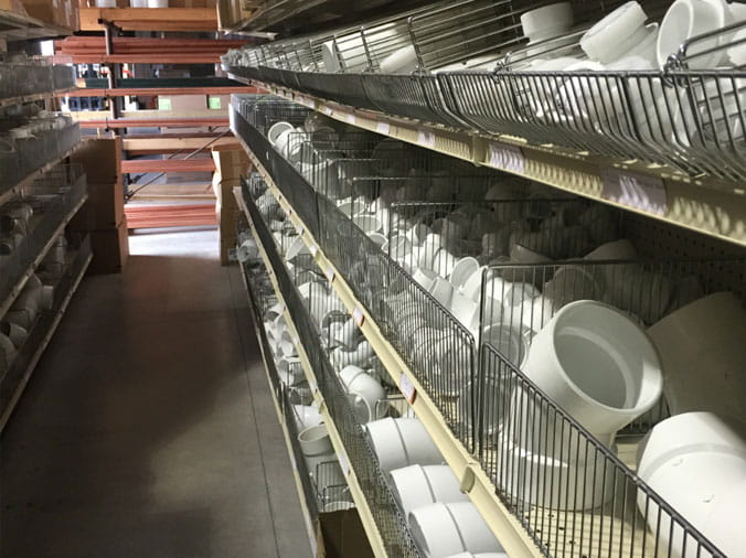 Shelves stocked with various PVC pipe parts and fittings at Dahl Greeley